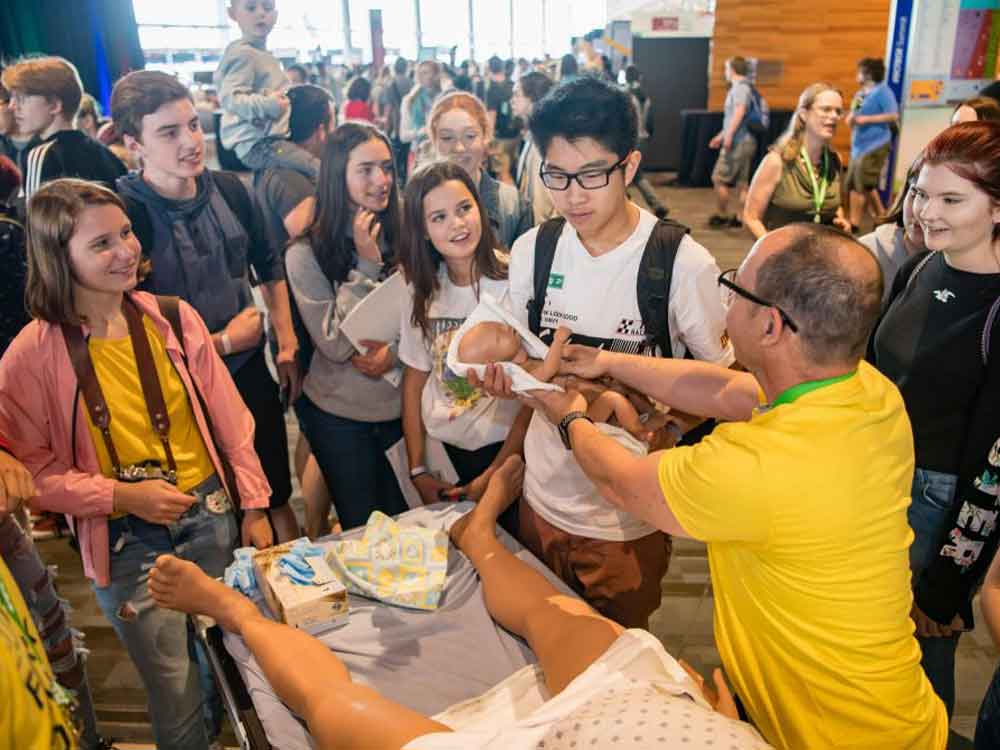 Students examining realistic human models at a nursing stand, as part of a technology fair at BCIT