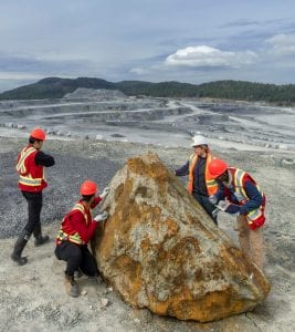 Mineral Exploration and Mining Technology students and their instructor examine the geology of a boulder at the Lafarge Texada Quarry on Texada Island, BC.