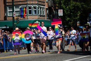 BCIT staff and students walking in the Vancouver Pride parade holding up the letters B C I T