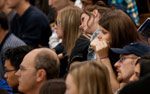 headshots of 8 or more students of various ages sitting in a lecture hall.