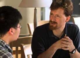 Two men talking while seated.