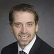 Wayne Hand headshot smiling wearing business attire.