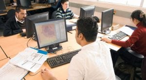 Students at their computers, working on GIS projects
