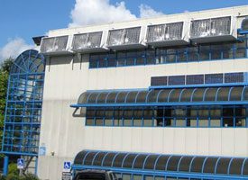 Image of ne25 building at the burnaby campus that has solar canopy modules on above the third floor windows.