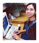 Student sitting at a desktop computer typing on a keyboard.