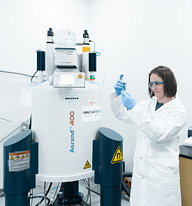 Person wearing a white lab coat holding a test tube in the phytoanalytics lab.