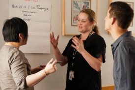 Photo of three people standing and talking together.