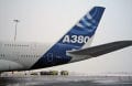 back half of an airplane with blue tail and white body.