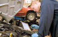 mechanic running diagnostics on a vehicle engine.