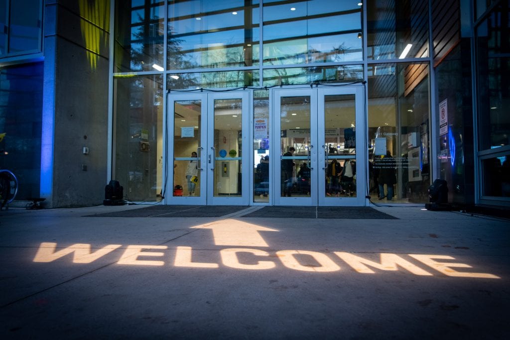 Welcome sign lighting up the ground at the entrance to a BCIT building.