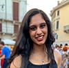 woman smiling with long brown hair at a market.