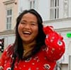 Asian woman smiling with long black hair on the street.