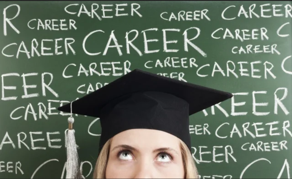 Woman wearing graduation cap in front of a chalkboard with the word
