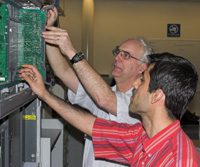 instructor shows male student something on a shelf