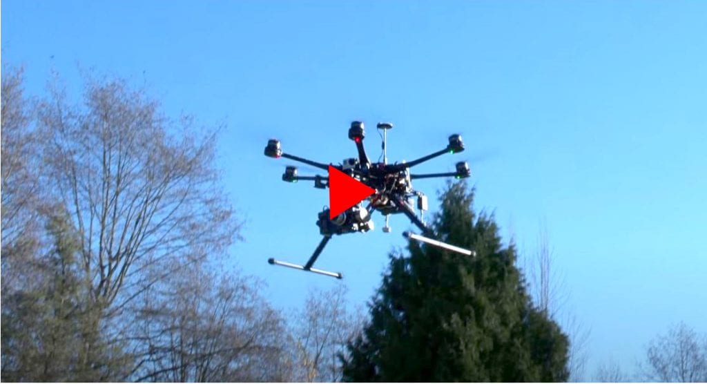 Hexacopter with camera mounted against blue sky