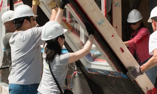 Building Science students holding a wall