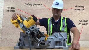 man in hard hat with hi vis vest using a miter saw