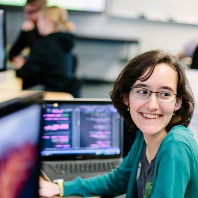 A smiling student in a computer lab