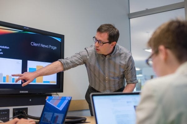 Man pointing at presentation during a software workshop.