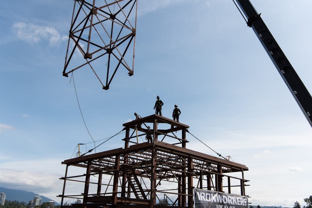 Three ironworkers standing on the steel platform