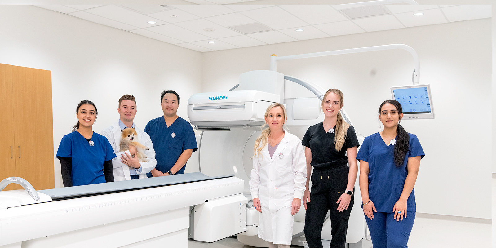 Nuclear Medicine staff around a gamma camera machine