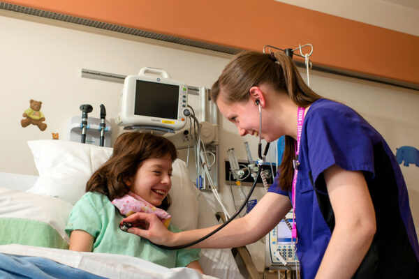 pediatric nurse and patient in hospital bed