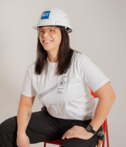 Rachel sitting in a chair in a white tshirt with a white hard hat on