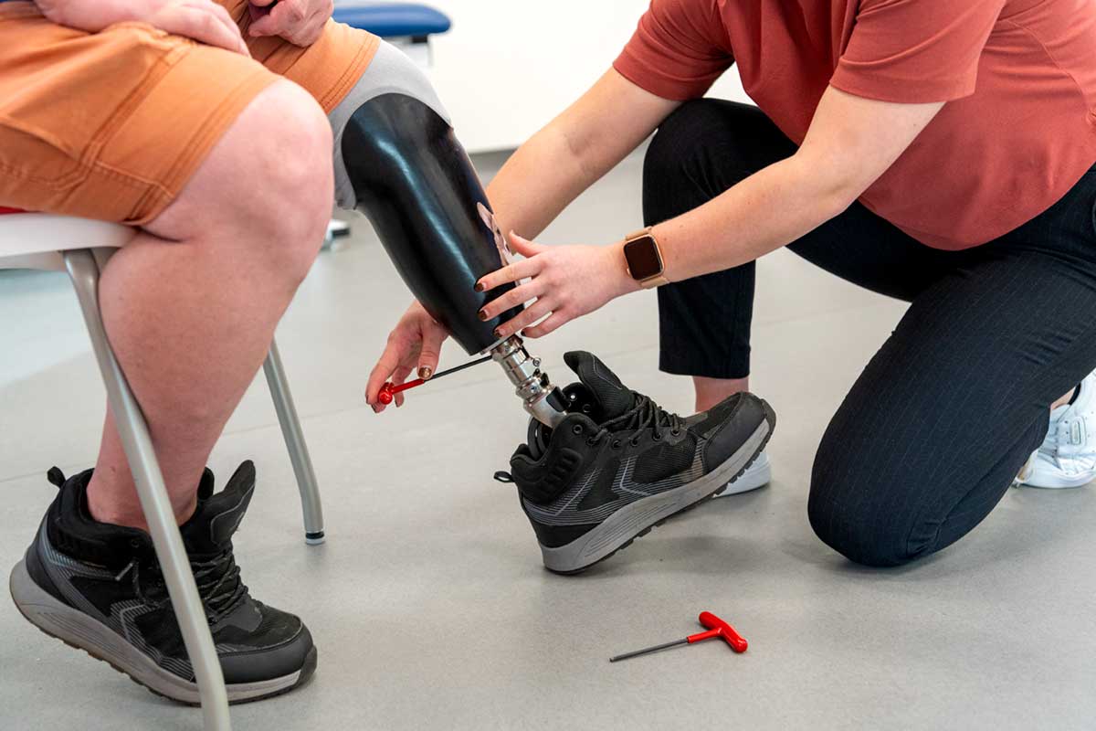 BCIT prosthetics and orthotics student adjusting a patient's prosthesis