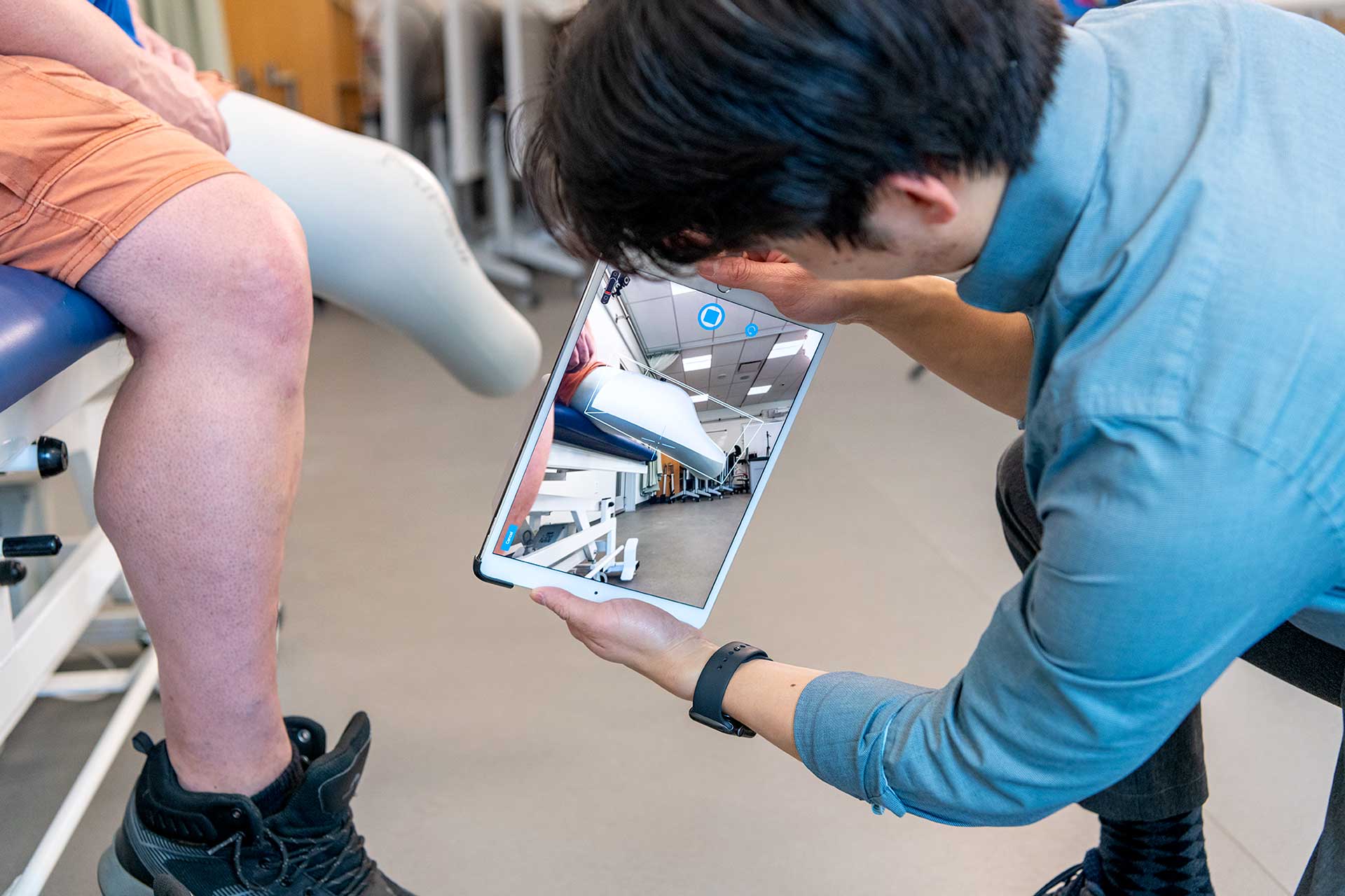 prosthetics and orthotics student using potable digital scanner on amputee patient