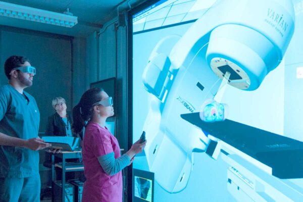 BCIT radiation therapy instructor and students using VERT machine.