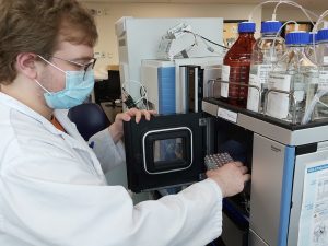 Person wearing a mask; working in a lab.