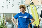 girl with short hair wearing a blue t-shirt with hands on her hips