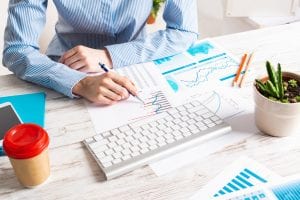 A person is sitting in front of a desk to study a chart