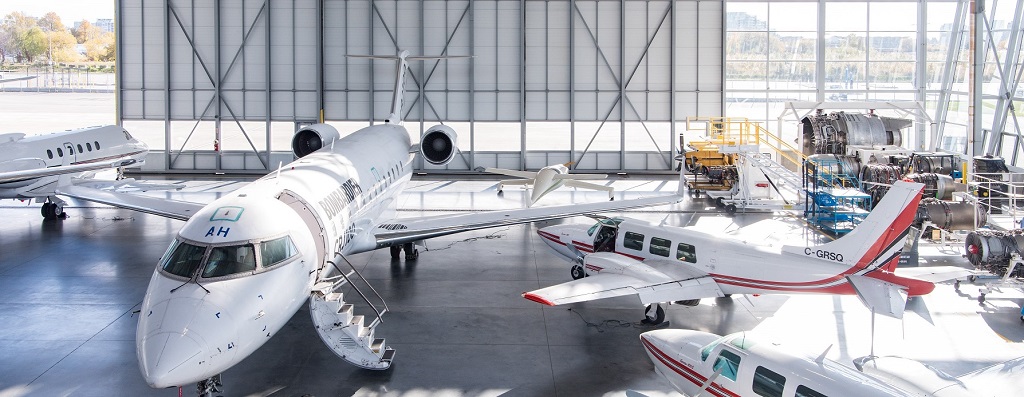 Three airplanes and equipment in hangargar