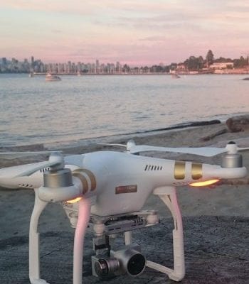 white drone on the beach with the city in the background