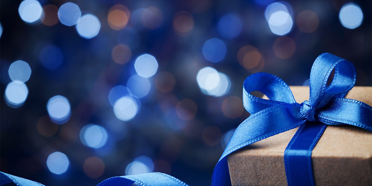 blue glitter background with brown gift wrapped in a blue ribbon