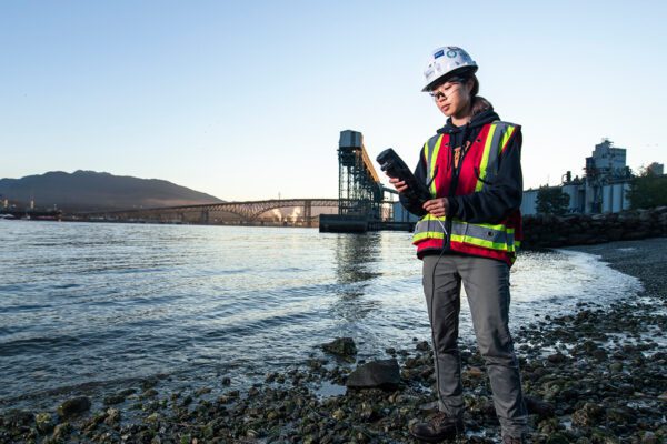 BCIT Applied and Natural Sciences grad tests water on the shore of Burrard Inlet.