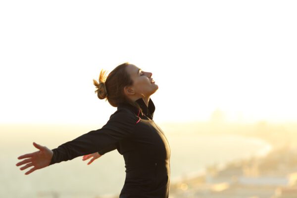 Runner relaxing breathing fresh air outstretching arms