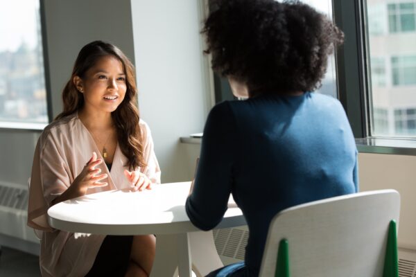 Two women talking at a work meeting