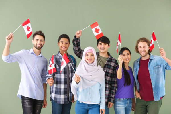 Group of students with Canadian flags on color background