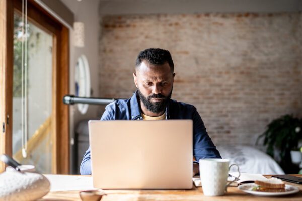 Mature man using laptop working at home