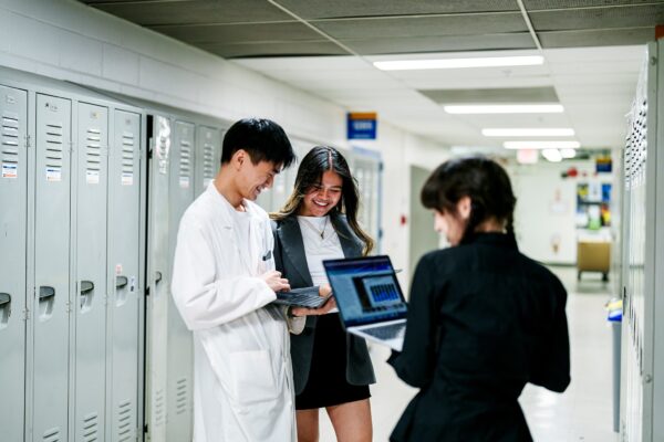 Food Technology students talking in a hallway with their laptops