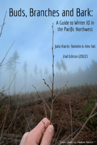 Book cover for "Buds, Branches, and Bark" by Julia Alards-Tomalin and Alex Tait. 2nd Edition (2022). Photo of a stick held by a hand in front of a foggy forest was taken by Andrew Takacs.