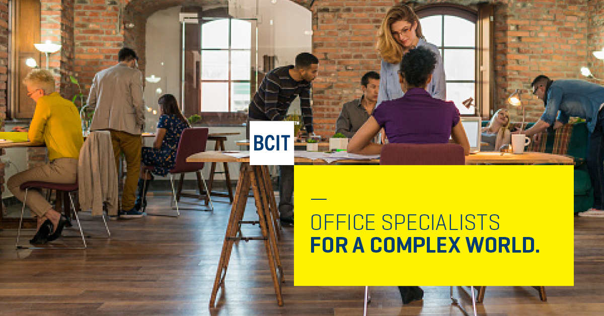 Many people work on computers or in small groups in a busy, open-plan office environment