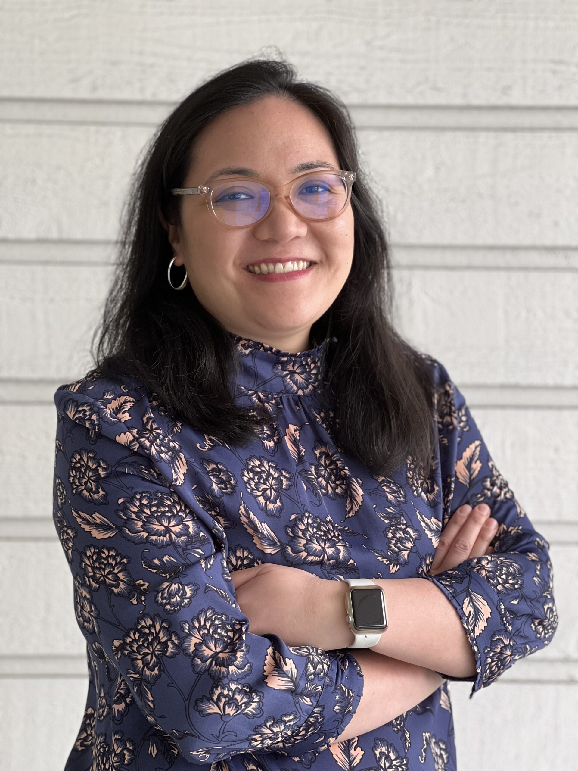 Joan in patterned blouse and arms folded