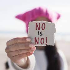 Woman holding a sign saying no is no