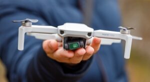 a close-up of someone holding a DJI mavic mini drone in their hand