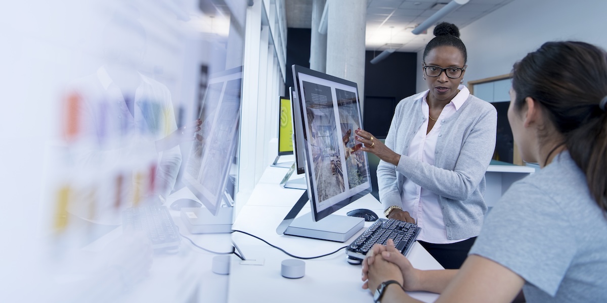 BCIT instructor and student are in front of a computer screen and discussing a project