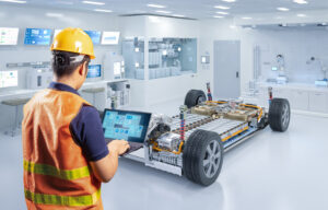 man with safety helmet and safety vest working on ev car