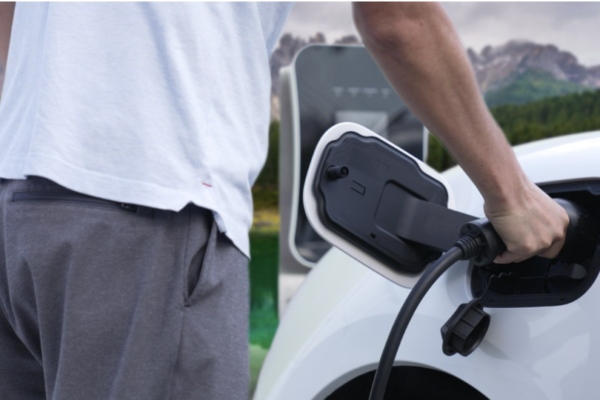 A man charging an electric vehicle